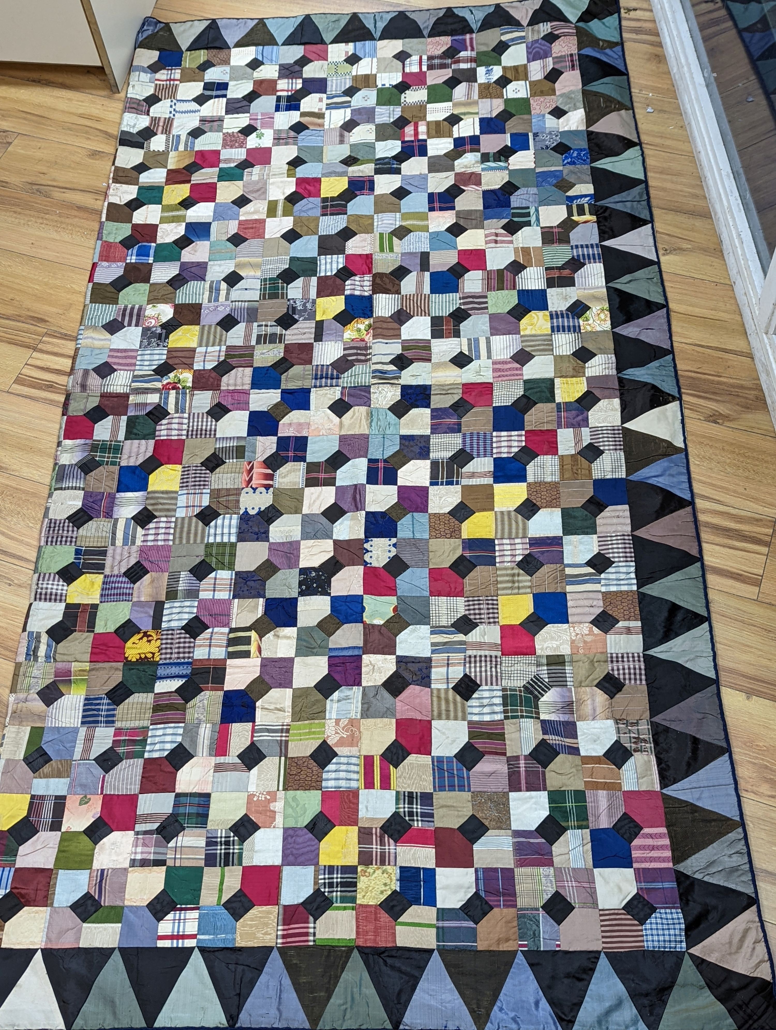 A Victorian silk patchwork bed cover, 220 cms x216 cms.